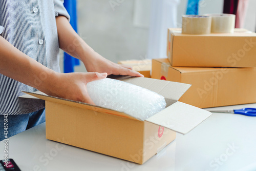 female warehouse worker are checking or seller packing ecommerce shipping order box for dispatching, preparing post courier delivery package or online sales, e-commerce concept.