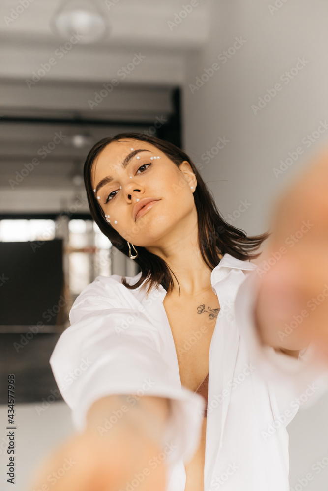 young woman with outstretched hands looking at camera on blurred background young woman with outstretched hands looking at camera on blurred background