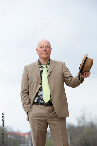 handsome bald man in his 50s in brown suit from the 1980s
