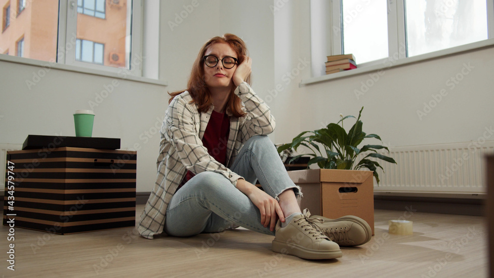 The girl sits on the floor in the apartment and suffers from boredom The girl sits on the floor in the apartment and suffers from boredom