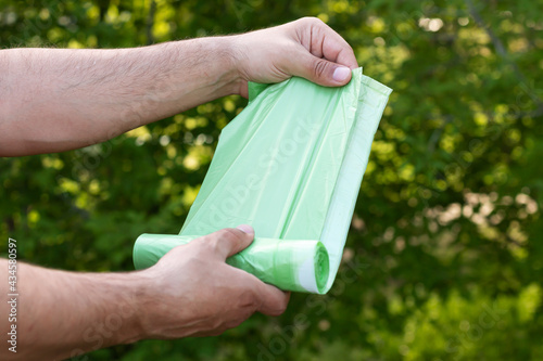 Holding eco plastic garbage bio bag in roll outdoors