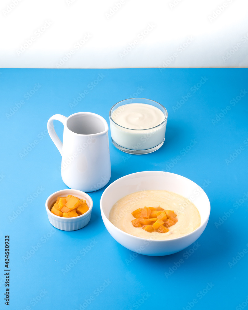 Mango yoghurt on blue background Mango yoghurt on blue background