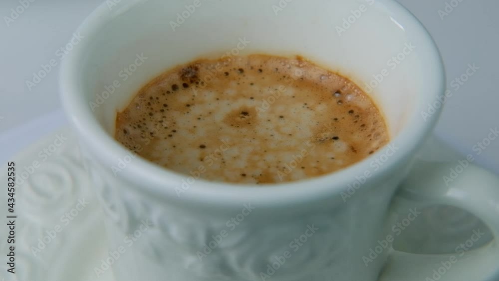 top view close-up on a white cup of coffee cappuccino, slow motion rotation on a turntable, lunch concept in a restaurant, cafe, enjoying breakfast, coffee break at home top view close-up on a white cup of coffee cappuccino, slow motion rotation on a turntable, lunch concept in a restaurant, cafe, enjoying breakfast, coffee break at home