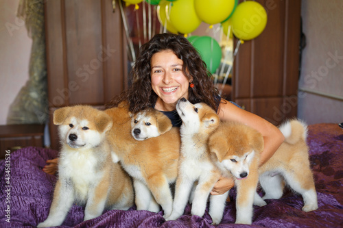 Handsome brunette girl have fun hugs and play with akita inu puppies