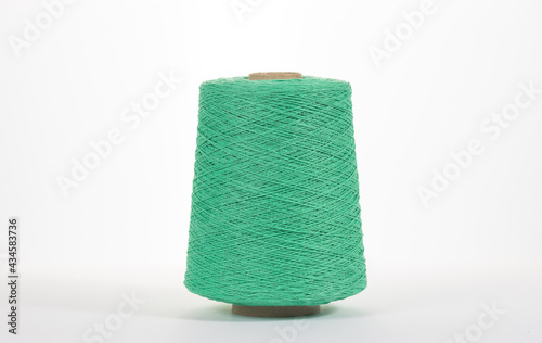 Green spool with cotton thread on white isolated background. photo