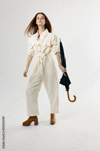 pretty woman in white jumpsuit with umbrella in hands protection from rain © SHOTPRIME STUDIO