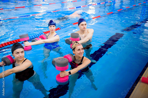 Avka aerobics in the swimming pool. A group of young people in training. photo
