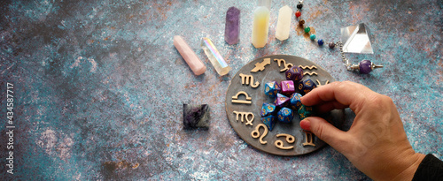 zodiac horoscope symbol with fortune-teller hands and healing crystals on rustic background photo