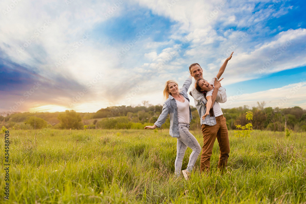 Happy family: mother father and child daughter on nature on sunset Happy family: mother father and child daughter on nature on sunset
