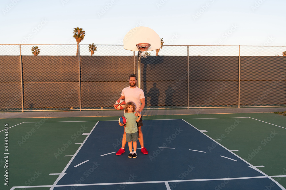 Obraz premium dad and kid boy play basketball. child hold sport ball. childhood and fatherhood.