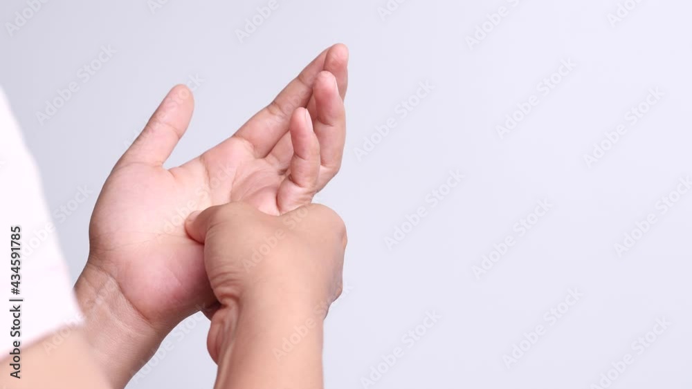 Close up young Asian women suffering pain in hand around finger joint and using the thumb to massage, exercise, treatment her painful. Concept of Office syndrome, Neuropathy, hand pain, Healthy Care. Close up young Asian women suffering pain in hand around finger joint and using the thumb to massage, exercise, treatment her painful. Concept of Office syndrome, Neuropathy, hand pain, Healthy Care.