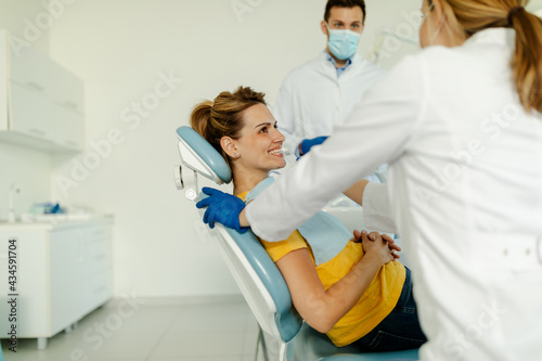 Dentist checks the level of teeth whitening the patient s teeth with a dentist s color.