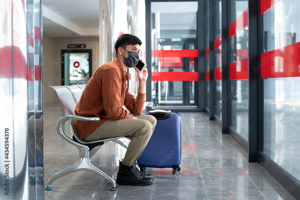 Fototapeta premium Man sitting at station talking on mobile phone