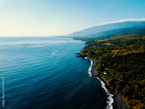 Aerial drone view of the beautiful black sandy beach in Bali, Indonesia