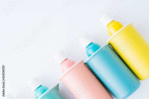 Colored bowl and jar, pantone, colored items diplayed on a white background, egg carrier, and different color paint on plastic container,   top view, flatlay, wallpaper type advertisement style. photo