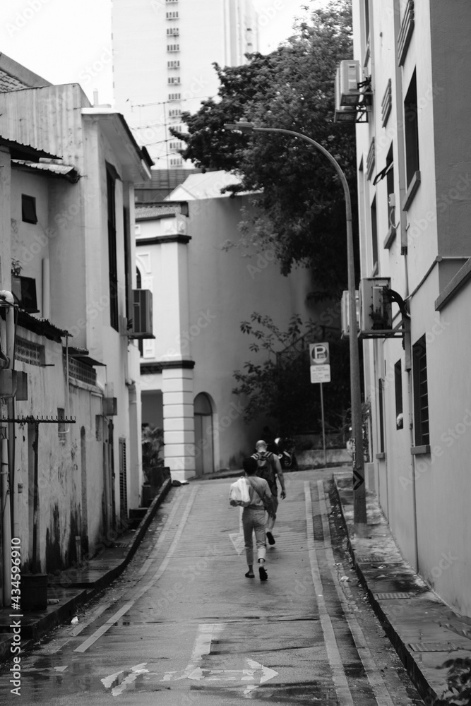 two people walking in a narrow street