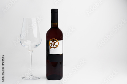 Red Wine bottle and glass on white background with copy space for text. Front view of the wine bottle. Full red wine bottle. With copy space. 