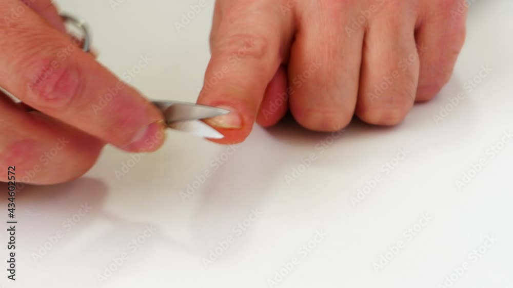 Manicure at home. Self-cut nails with scissors at home. Men's hands with scissors on a white background. Man Cuts Nails Closeup Manicure at home. Self-cut nails with scissors at home. Men's hands with scissors on a white background. Man Cuts Nails Closeup