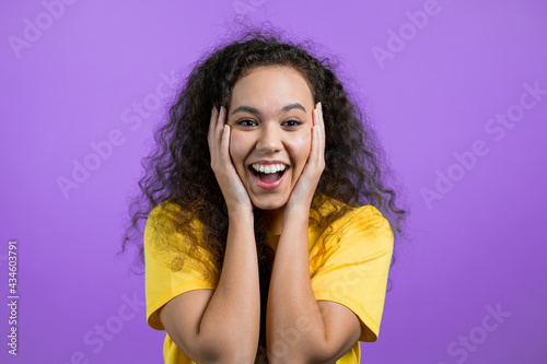 Mixed race woman is very glad, she screaming loud. Concept of sales, profitable offer. Excited happy lady on purple studio background.