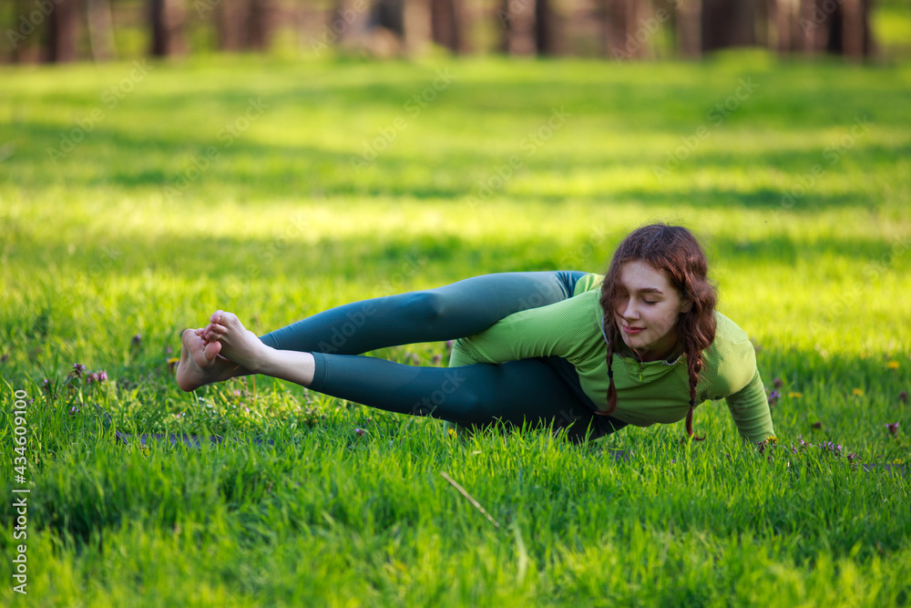 Athletic sportive girl in park on green grass doing fitness exercises stretching the body, healthy lifestyle in pure nature Athletic sportive girl in park on green grass doing fitness exercises stretching the body, healthy lifestyle in pure nature