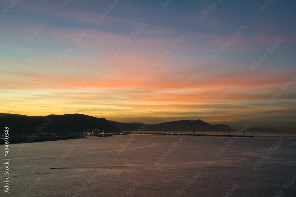 atardecer sobre el mar con puerto de fondo atardecer sobre el mar con puerto de fondo