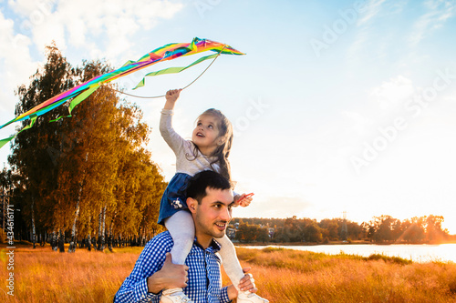 happy father with a little daughter, having fun in nature, in the rays of the sunset