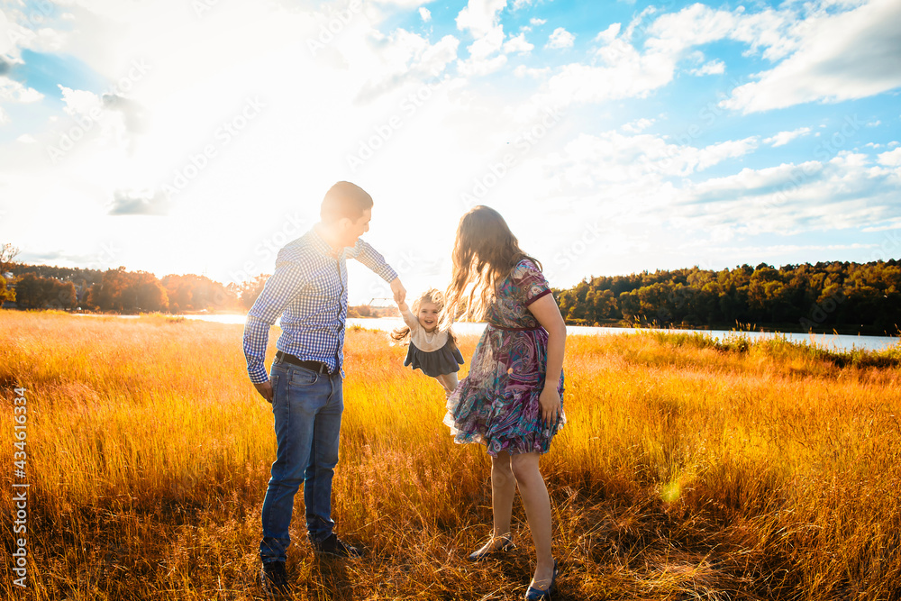 happy family at sunset, having fun with a child in nature happy family at sunset, having fun with a child in nature