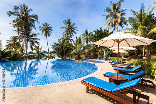 Beautiful tropical beach front hotel resort with swimming pool, sunshine, summer holidays vacation