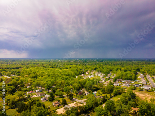 An aerial view of a big storm off in the horizon with a visible downpour.