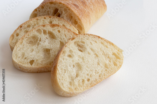 slice of ciabatta bread isolated on white background, side view photo