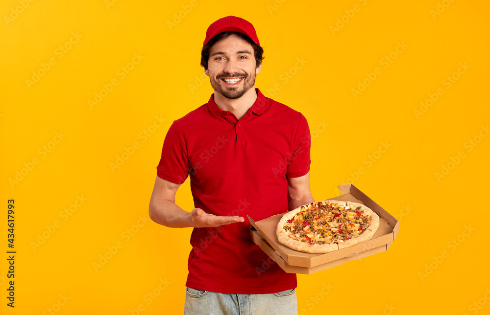 Young bearded pizza delivery man isolated on orange background. Home delivery. Young bearded pizza delivery man isolated on orange background. Home delivery.