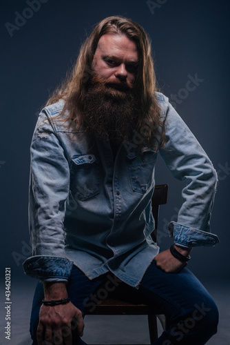 Close up portrait of handsome manly guy with beard posing in studio on a isolated background.