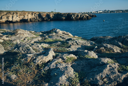 woman traveler sitting on stones near the sea landscape beach sunset clear water