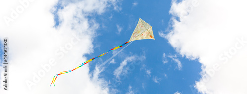 Self-painted kite flies against a blue sky. Creatively painted kite. Kite flying. Selbst bemalter Drachen fliegt vor blauem Himmel. Kreativ bemalter Drachen. Drachen fliegen.  photo