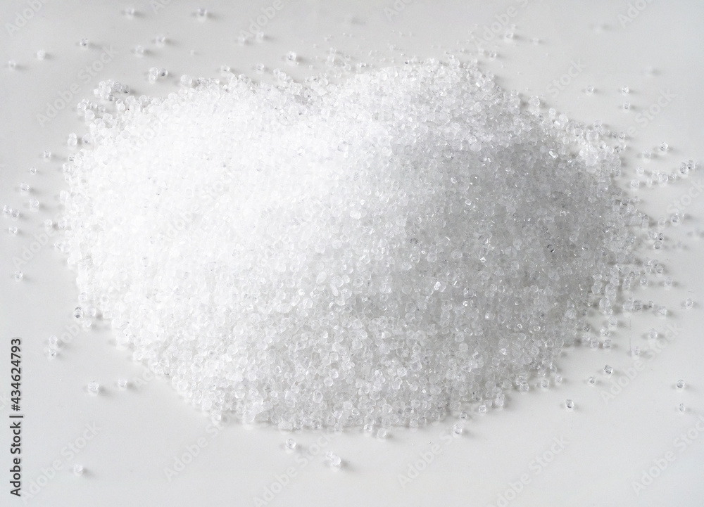 handful of fructose crystalline sugar on white