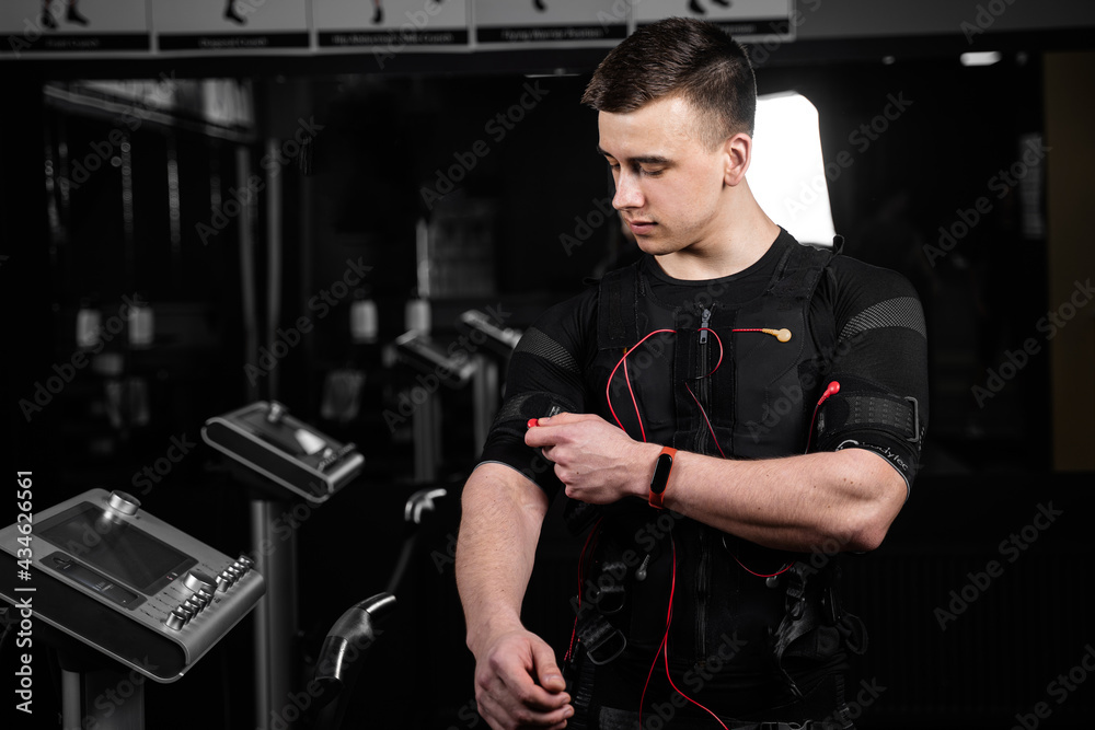 EMS suit with red wires for electro impulse stimulation for body. Training in GYM. EMS suit with red wires for electro impulse stimulation for body. Training in GYM.
