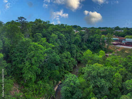 a stunning aerial shot of the running waters of the Big Creek River surrounded by vast miles of lush green trees and plant with rocks on the banks of the river and gorgeous sky at Vickery Creek GA photo