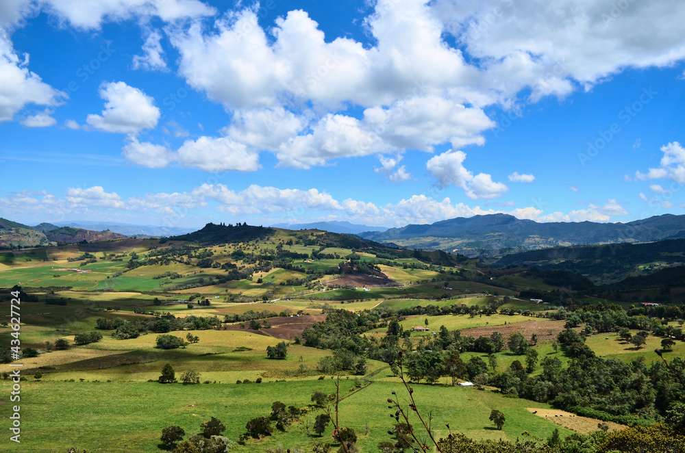 A view of the mountains, green foliage and blue sky at the natural park of Guatavita, located in the Cordillera Oriental of the Colombian Andes in Sesquile, Almeidas Province, Cundinamarca, Colombia.