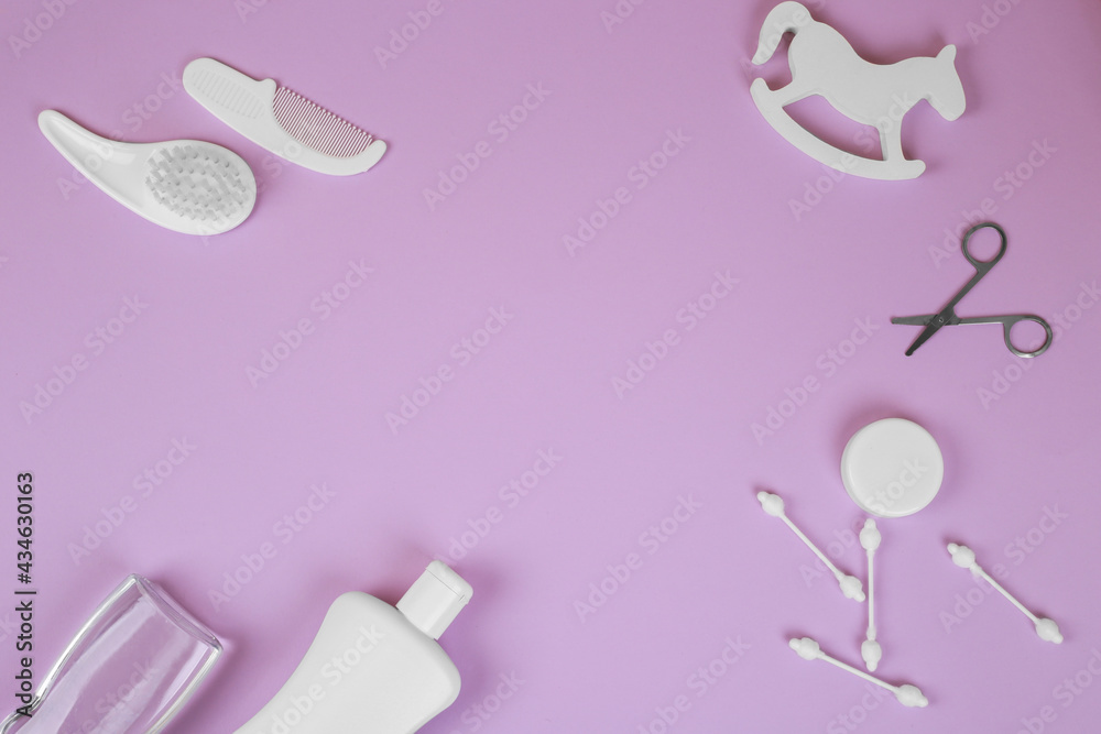 Baby accessories on lavender background, flat lay. Composition with baby accessories and space for text. Baby cotton swabs, scissors, combs, oil, baby rattle Baby accessories on lavender background, flat lay. Composition with baby accessories and space for text. Baby cotton swabs, scissors, combs, oil, baby rattle
