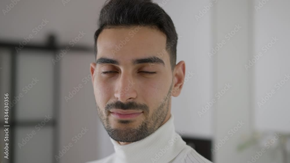 Headshot portrait of confident handsome young man turning to camera smiling. Confident bearded Middle Eastern guy posing in kitchen at home indoors. Lifestyle and cooking concept Headshot portrait of confident handsome young man turning to camera smiling. Confident bearded Middle Eastern guy posing in kitchen at home indoors. Lifestyle and cooking concept