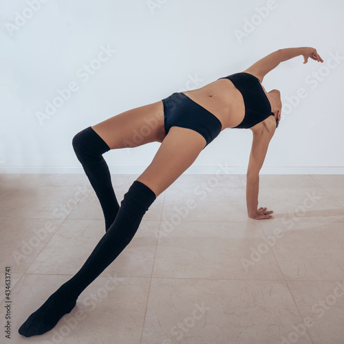 Young elastic woman doing yoga in a black lingerie