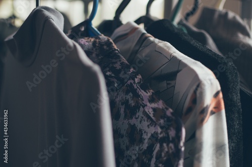Clothes on hanger in dressing room, black and gray tones
