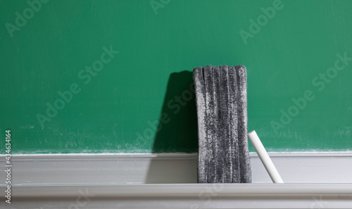 Eraser and chalk on old school chalkboard  photo