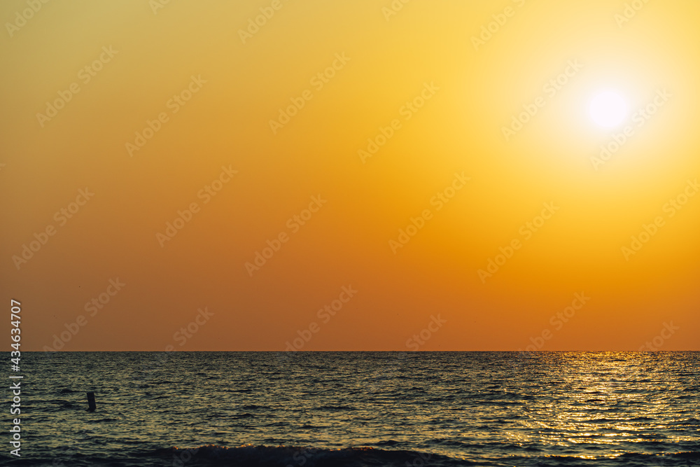 Scenic view of Sun in orange sky reflecting on the water during sunset