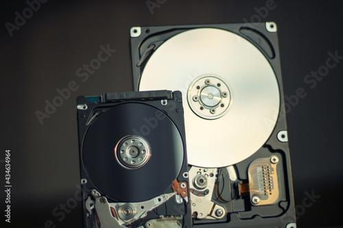 Disassembled hard drive from the computer with mirror effect. Opened hard drive from the computer hard disk drive (HDD)