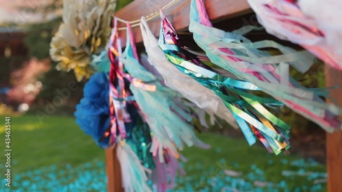 Colorful confetti sprinkling, glittering, and fluttering in the wind. Shine tinsel during holiday, oudoor birthday party.  photo