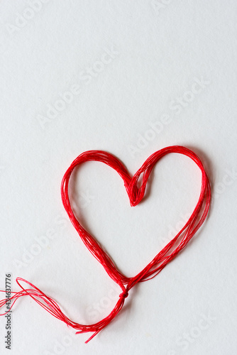 red heart made of red thread on a white background