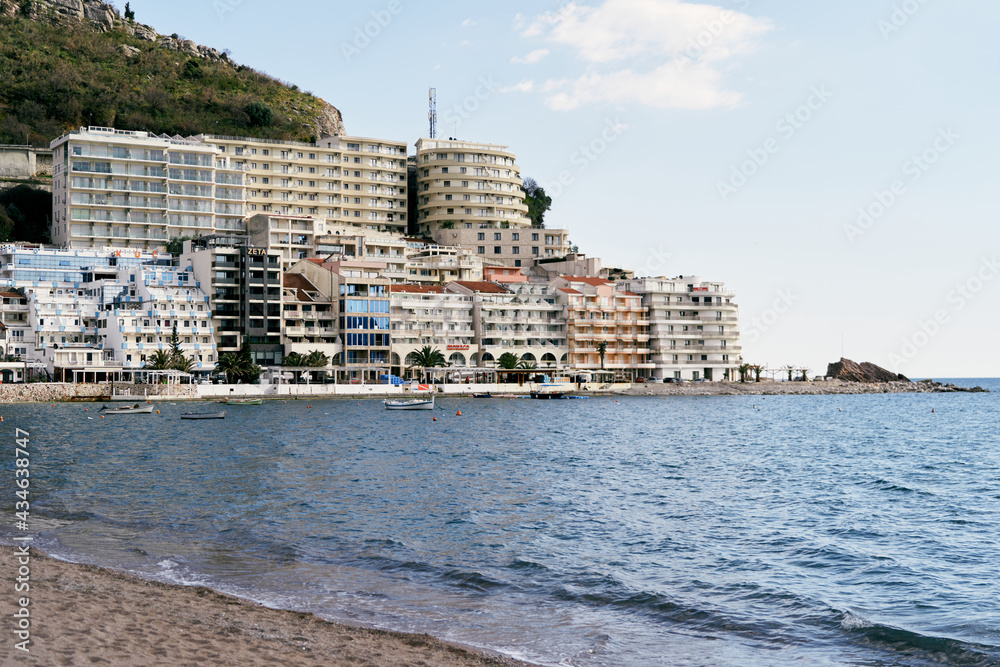 Beach and sea on the background of new beautiful buildings in the town of Rafailovici, Montenegro