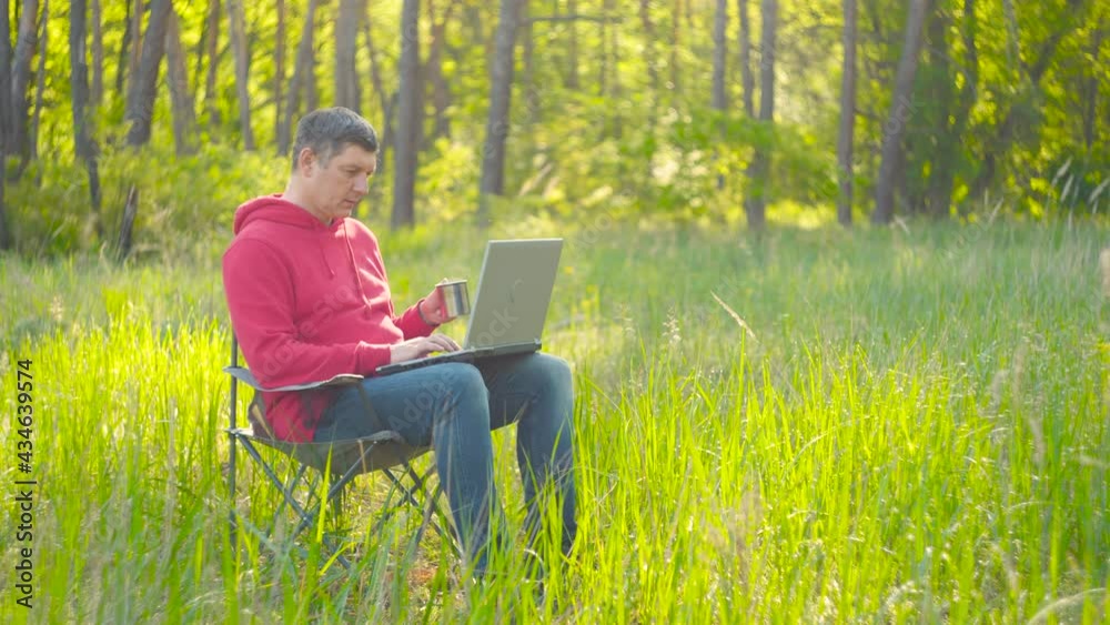 Man working on laptop in summer forest Man working on laptop in summer forest