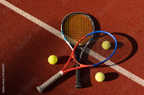 A tennis racket and new tennis ball on a freshly painted tennis court © Angelov